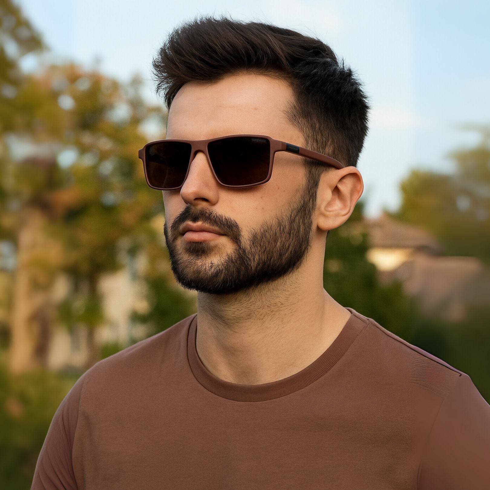 Man wearing sunglasses with a blurred outdoor background