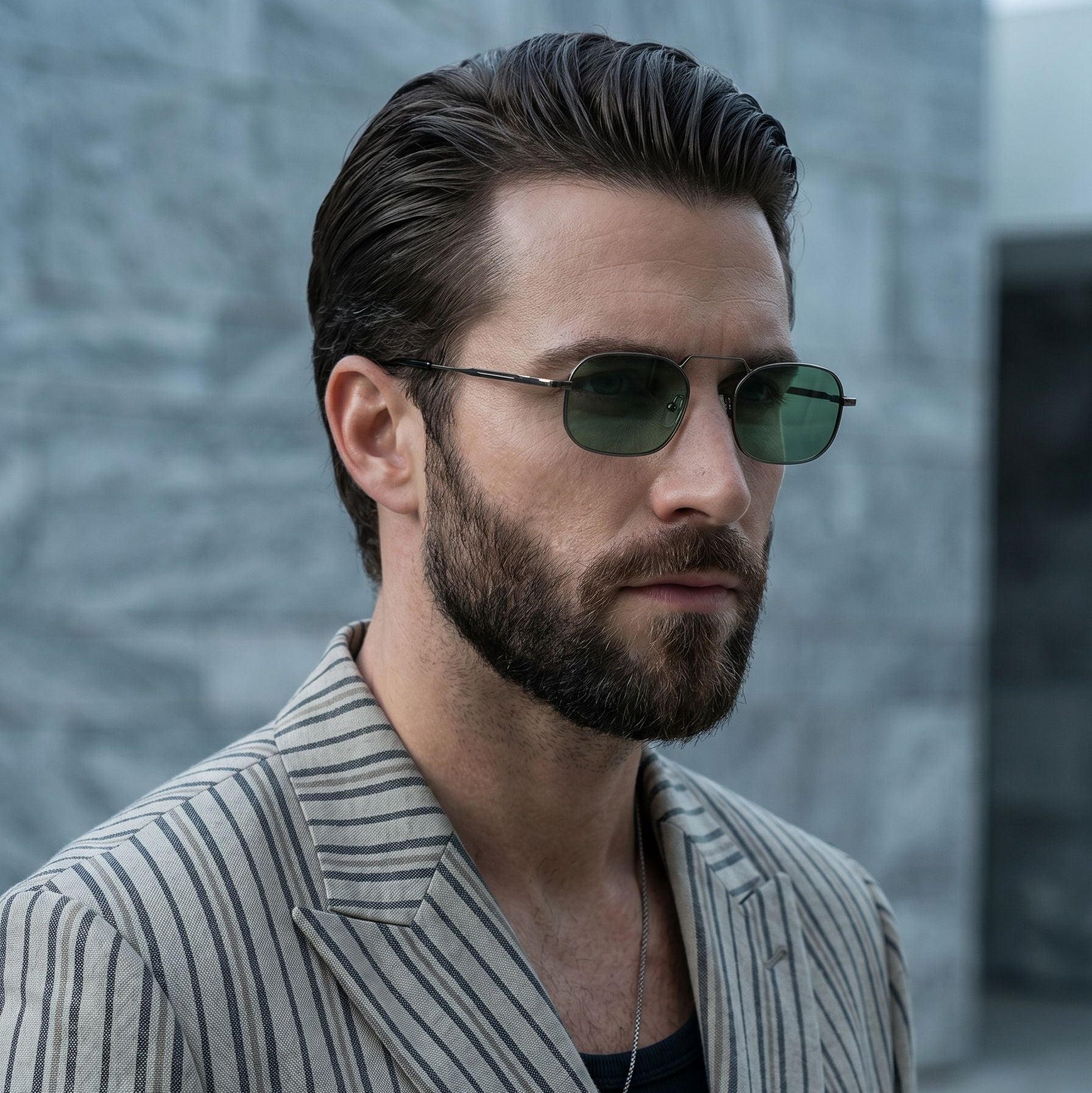Man wearing sunglasses and a striped suit against a blurred background