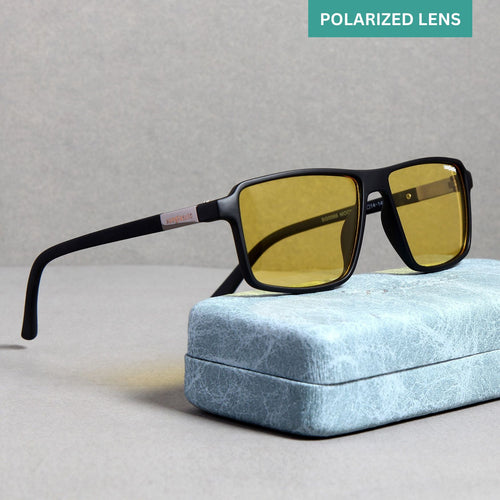 A pair of black-framed, yellow polarized rectangle sunglasses resting on a blue textured surface.