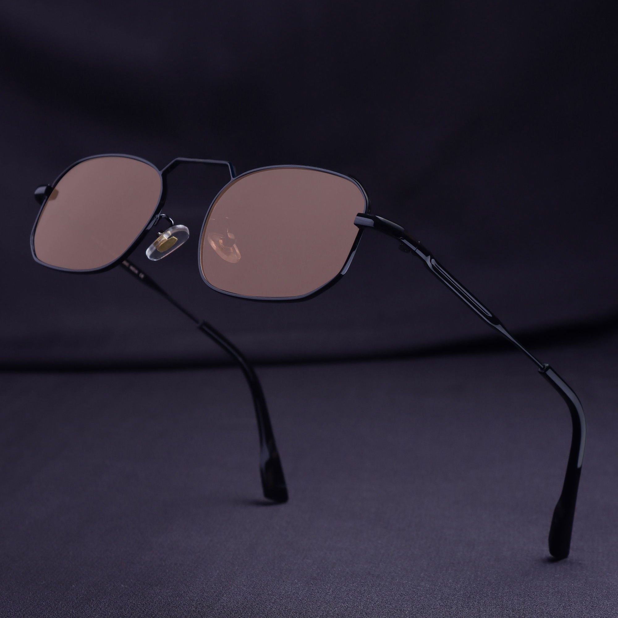 Sunglasses with brown lenses and black frame on a dark background