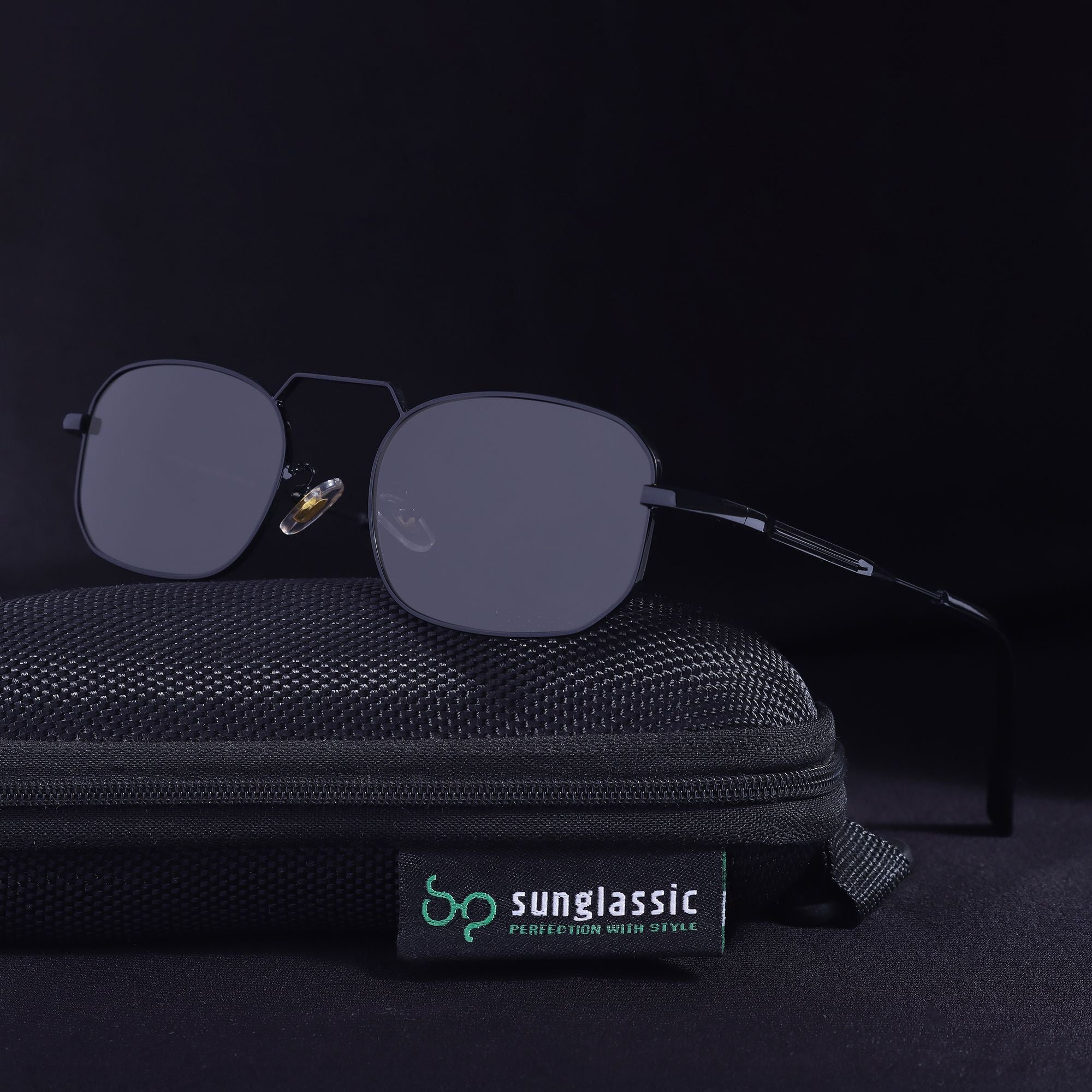 Sunglasses with a black case on a dark background